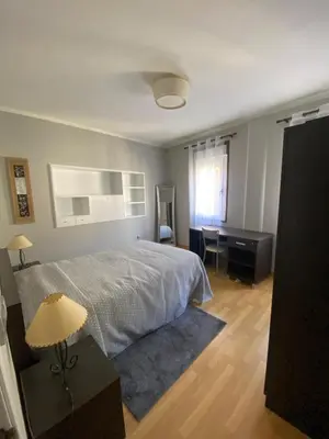 a bedroom with a bed and a desk and a lamp at PISO EN ESTACION DE MONFORTE DE LEMOS in Monforte de Lemos