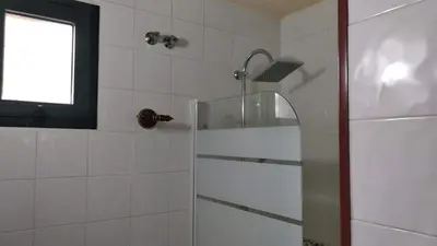 a bathroom with a shower with a glass door at El Descanso de Sanabria in Trefacio