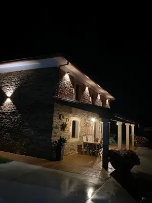 a stone building with lights on it at night at Casa Fontes Rosas in Touro