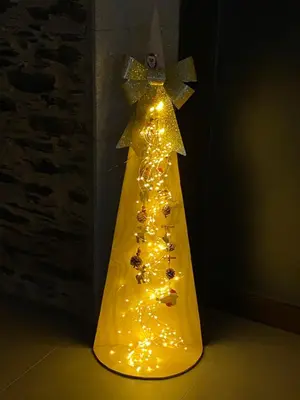 a yellow christmas tree with lights on it at Casa Fontes Rosas in Touro