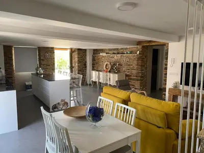 a living room with a table and a yellow couch at Casa Fontes Rosas in Touro