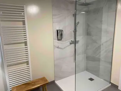 a shower with a glass door in a bathroom at Casa Fontes Rosas in Touro