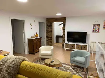 a living room with a yellow couch and a television at Casa Fontes Rosas in Touro