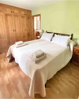 a bedroom with a large white bed with towels on it at Casa Outeiro in Betanzos