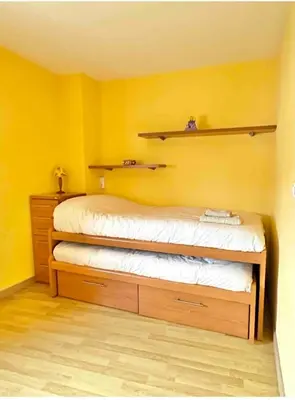 a bedroom with yellow walls and a bed with shelves at Casa Outeiro in Betanzos