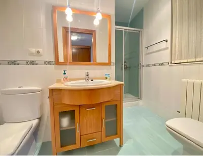 a bathroom with a sink and a toilet and a mirror at Casa Outeiro in Betanzos