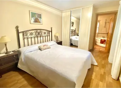 a bedroom with a large white bed and a mirror at Casa Outeiro in Betanzos