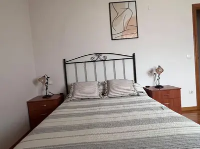 a bedroom with a large bed with two night stands at Apartamento Cantabrico vistas a la Ría deRibadeo in Ribadeo