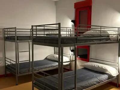a room with three bunk beds in a room at ALBERGUE A POBRA DO BROLLON in Puebla del Brollón