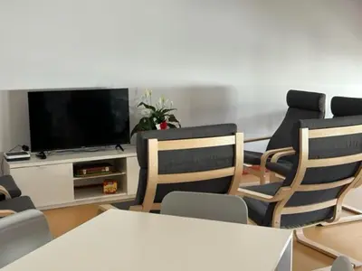 a living room with two chairs and a flat screen tv at ALBERGUE A POBRA DO BROLLON in Puebla del Brollón