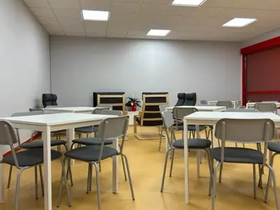 a room with tables and chairs in a classroom at ALBERGUE A POBRA DO BROLLON in Puebla del Brollón
