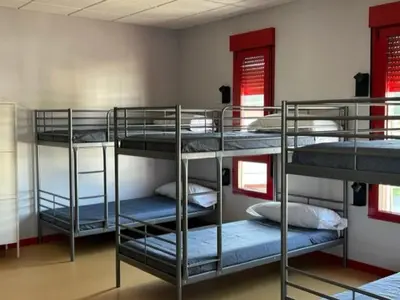 a room with three bunk beds in a room at ALBERGUE A POBRA DO BROLLON in Puebla del Brollón