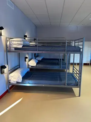 a room with three bunk beds in a room at ALBERGUE A POBRA DO BROLLON in Puebla del Brollón