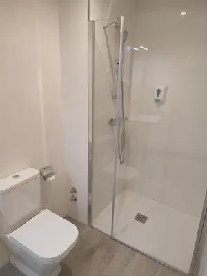 a white bathroom with a toilet and a shower at Pensión SP 55 by Bossh! Hotels in Santiago de Compostela