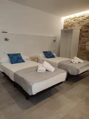 two beds in a hotel room with towels on them at Pensión SP 55 by Bossh! Hotels in Santiago de Compostela