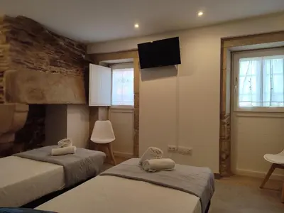 a bedroom with two beds and a tv on the wall at Pensión SP 55 by Bossh! Hotels in Santiago de Compostela
