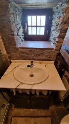 a small bathroom with a sink and a window at Casa Rural Maria de Isidro in Caboalles de Arriba