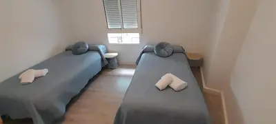 two beds in a small room with slippers on them at La Huella del Peregrino - Ionut Preda in Palas de Rei