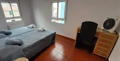 a bedroom with a bed and a desk and two windows at La Huella del Peregrino - Ionut Preda in Palas de Rei