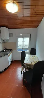 a kitchen with a table and chairs in a room at La Huella del Peregrino - Ionut Preda in Palas de Rei