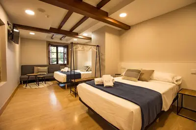 a hotel room with two beds and a mirror at hostal Nomade Santiago in Santiago de Compostela