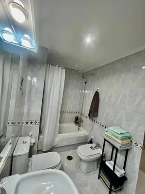 a bathroom with a toilet and a sink and a tub at Curros Enríquez MR in Ourense