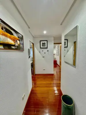 a hallway of a home with white walls and wood floors at Curros Enríquez MR in Ourense
