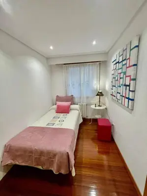 a bedroom with a bed and a table and a window at Curros Enríquez MR in Ourense