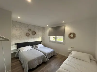 a bedroom with two beds and a window at Pensión Os Mollados in O Pedrouzo