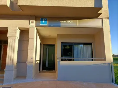 a building with a sign that reads hudos at Pensión Os Mollados in O Pedrouzo
