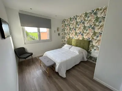 a small bedroom with a bed and a window at Pensión Os Mollados in O Pedrouzo