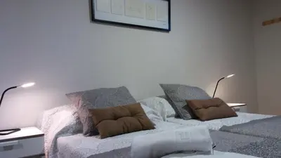 a bedroom with a bed with two pillows on it at Alma del Camino - Rooms & Albergue in Sarria