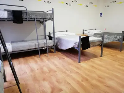 two bunk beds in a room with a wooden floor at Alma del Camino - Rooms & Albergue in Sarria