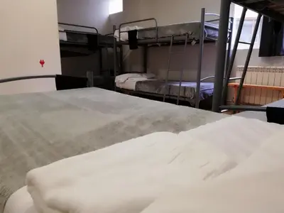 two beds in a room with two bunk beds at Alma del Camino - Rooms & Albergue in Sarria