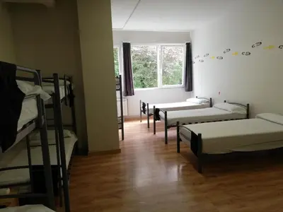 a room with three bunk beds and a window at Alma del Camino - Rooms & Albergue in Sarria