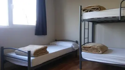 two bunk beds in a room with a window at Alma del Camino - Rooms & Albergue in Sarria
