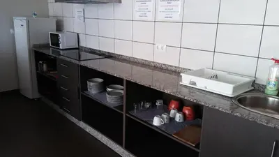 a kitchen with a sink and a counter with dishes at Alma del Camino - Rooms & Albergue in Sarria