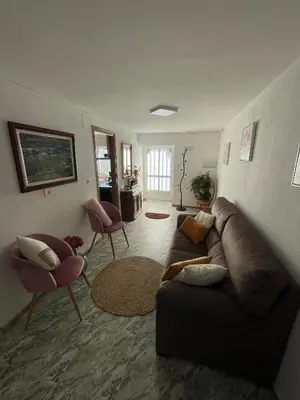 a living room with a brown couch and two chairs at A Casa da Torre Peruscallo in Belante