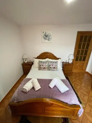 a bedroom with a wooden bed with two towels on it at A Casa da Torre Peruscallo in Belante
