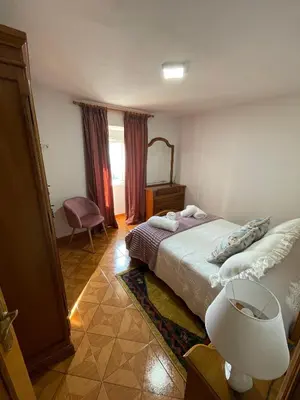 a bedroom with a bed and a chair and a window at A Casa da Torre Peruscallo in Belante