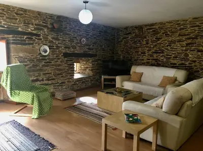 a living room with a couch and a brick wall at Casa da Forxa, renovated former forge/ smithy in Lugo