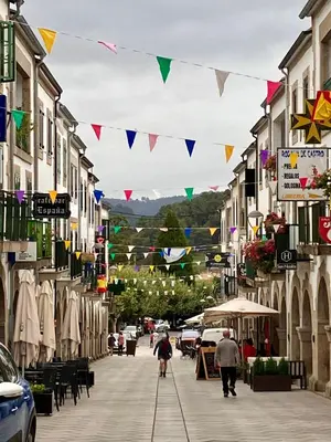 a street with flags and people walking down the street at Casa da Forxa, renovated former forge/ smithy in Lugo