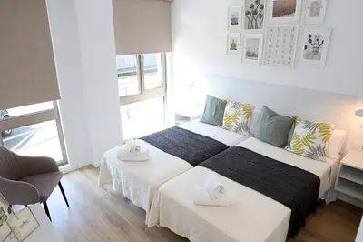 a bedroom with two beds and a chair in it at Pedro Luxury in Padrón