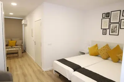 a bedroom with a white bed with yellow pillows at Pedro Luxury in Padrón