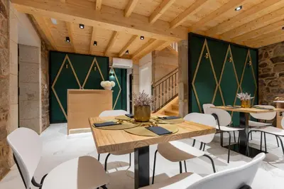 a dining room with a table and chairs and a glass door at Hostal HCELENIS in Caldas de Reis