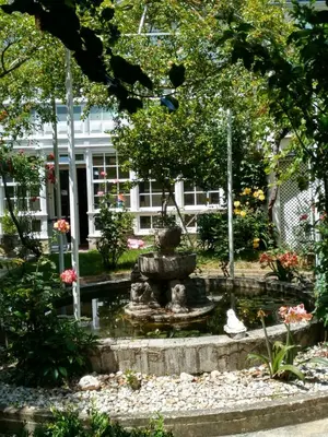a garden with a fountain in front of a building at Pension-Albergue Don Alvaro in Sarria
