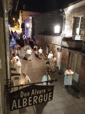 a group of people in white uniforms walking down a street at Pension-Albergue Don Alvaro in Sarria