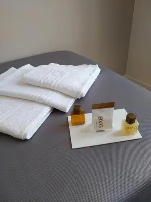 a bed with two white towels and two boxes on it at Pension-Albergue Don Alvaro in Sarria