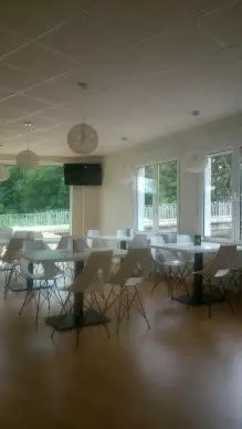 a large room with tables and chairs and windows at Pensión-Albergue Puente Ribeira in Sarria