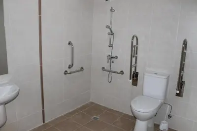 a bathroom with a shower with a toilet and a sink at Pensión-Albergue Puente Ribeira in Sarria